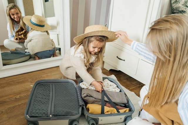 mother and daughter is packing the suitcase with smiley face